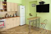 Virtuvės erdvėje - valgomasis stalas su kėdėmis, indai, stalo įrankiai 
